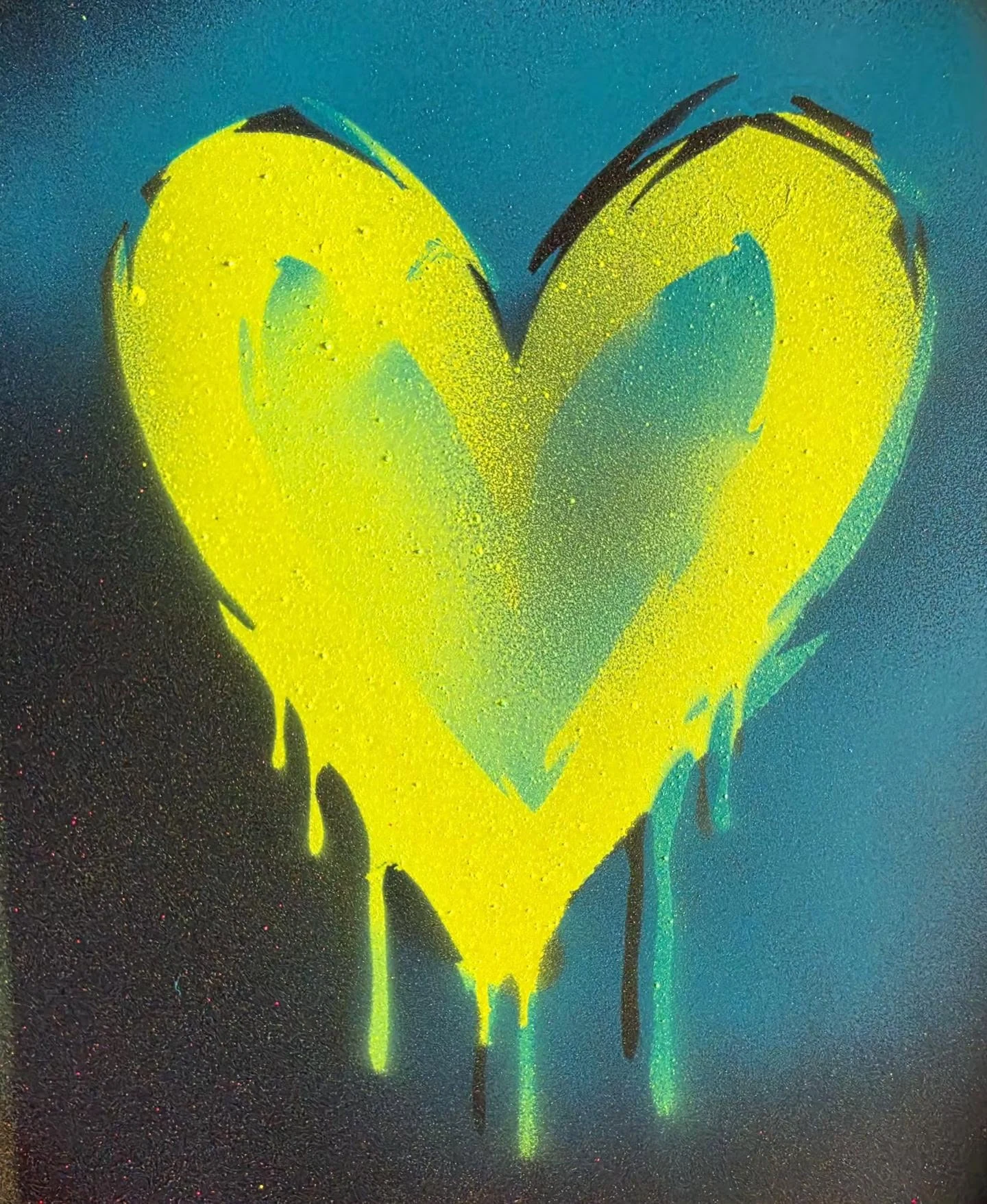 Leuchtendes gelbes Graffiti-Herz auf dunklem Hintergrund